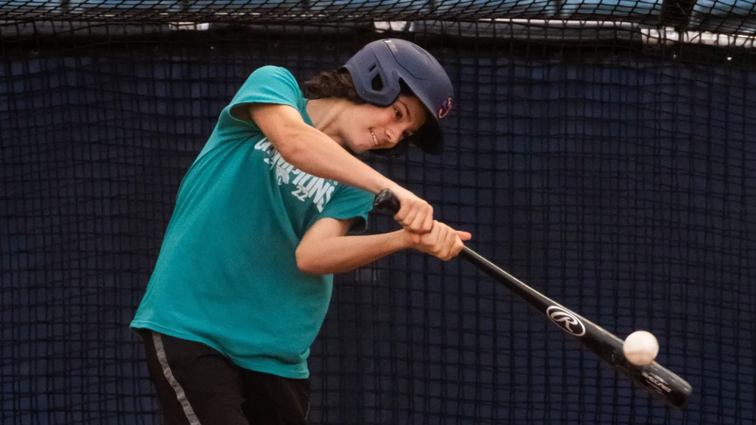 A guest taking a swing in a ballpark batting cage