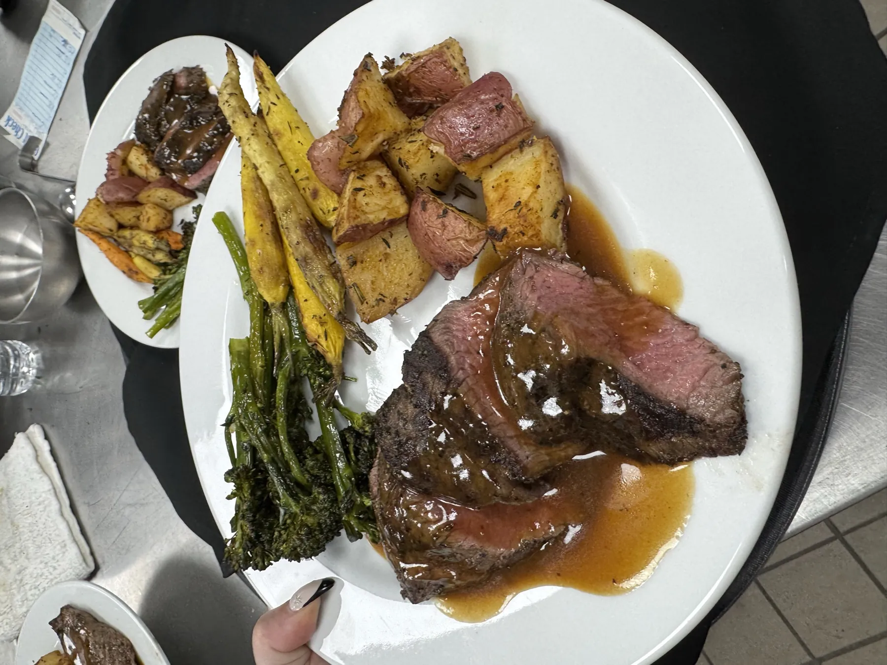 Plated steak with roasted potatoes and seasonal vegetables