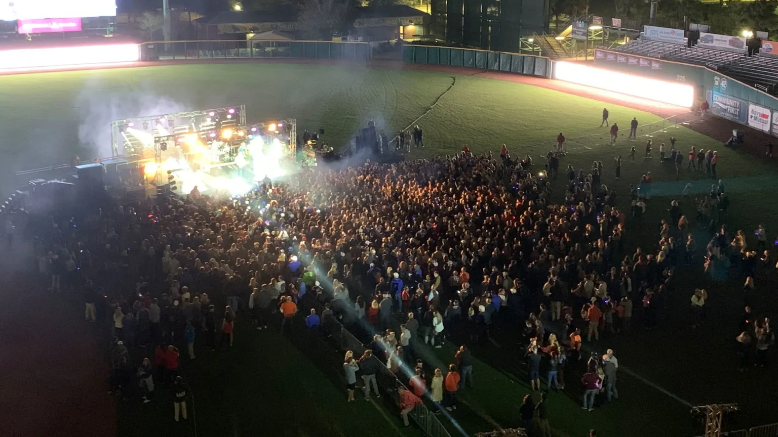 A nighttime concert crowd gathered on the field