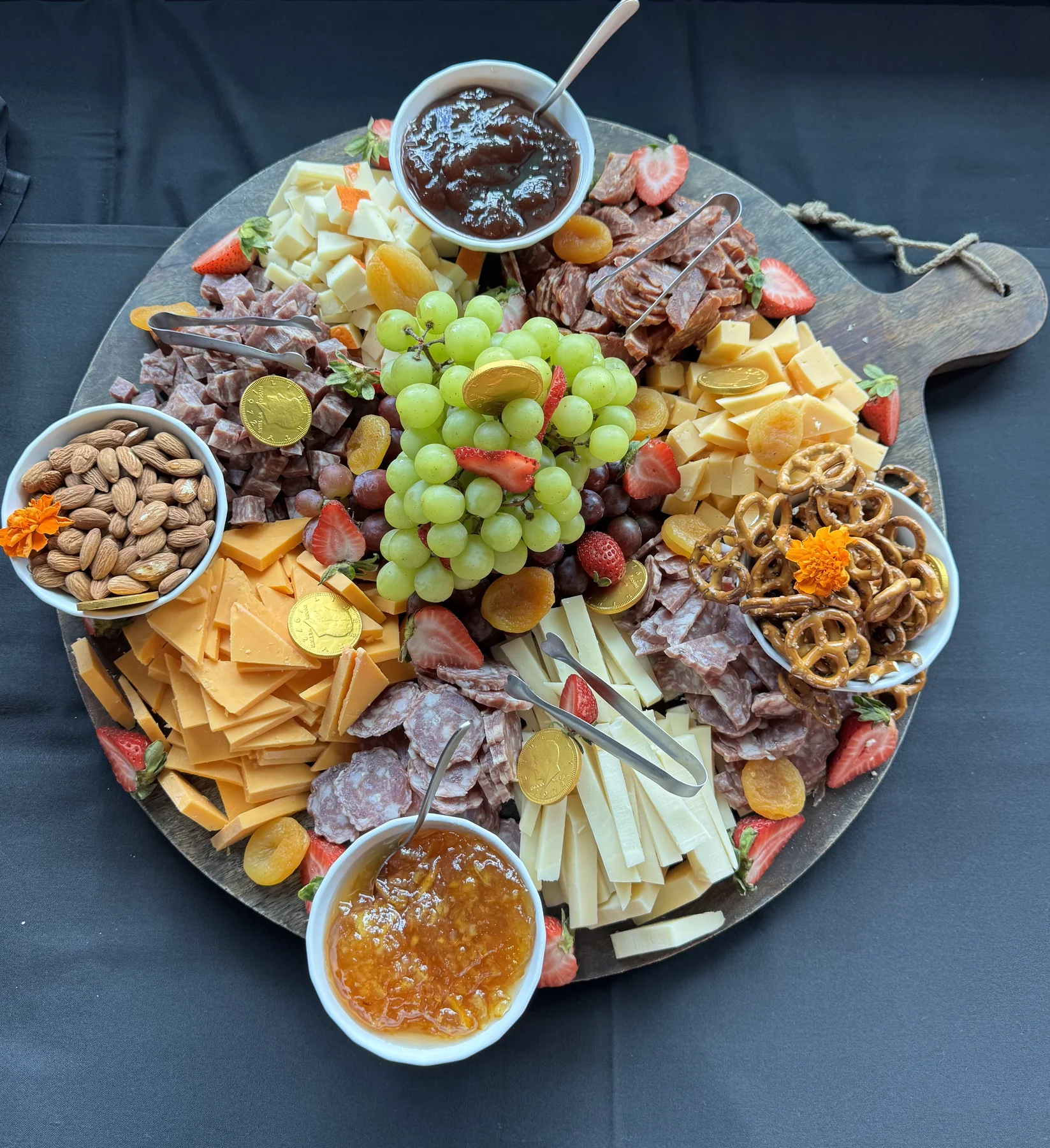Charcuterie board with meats, cheeses, fruit, nuts and pretzels