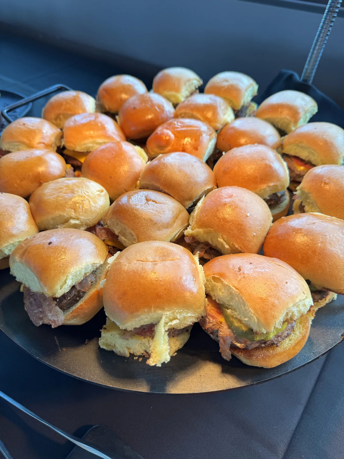 Tray of cheeseburger sliders on toasted rolls