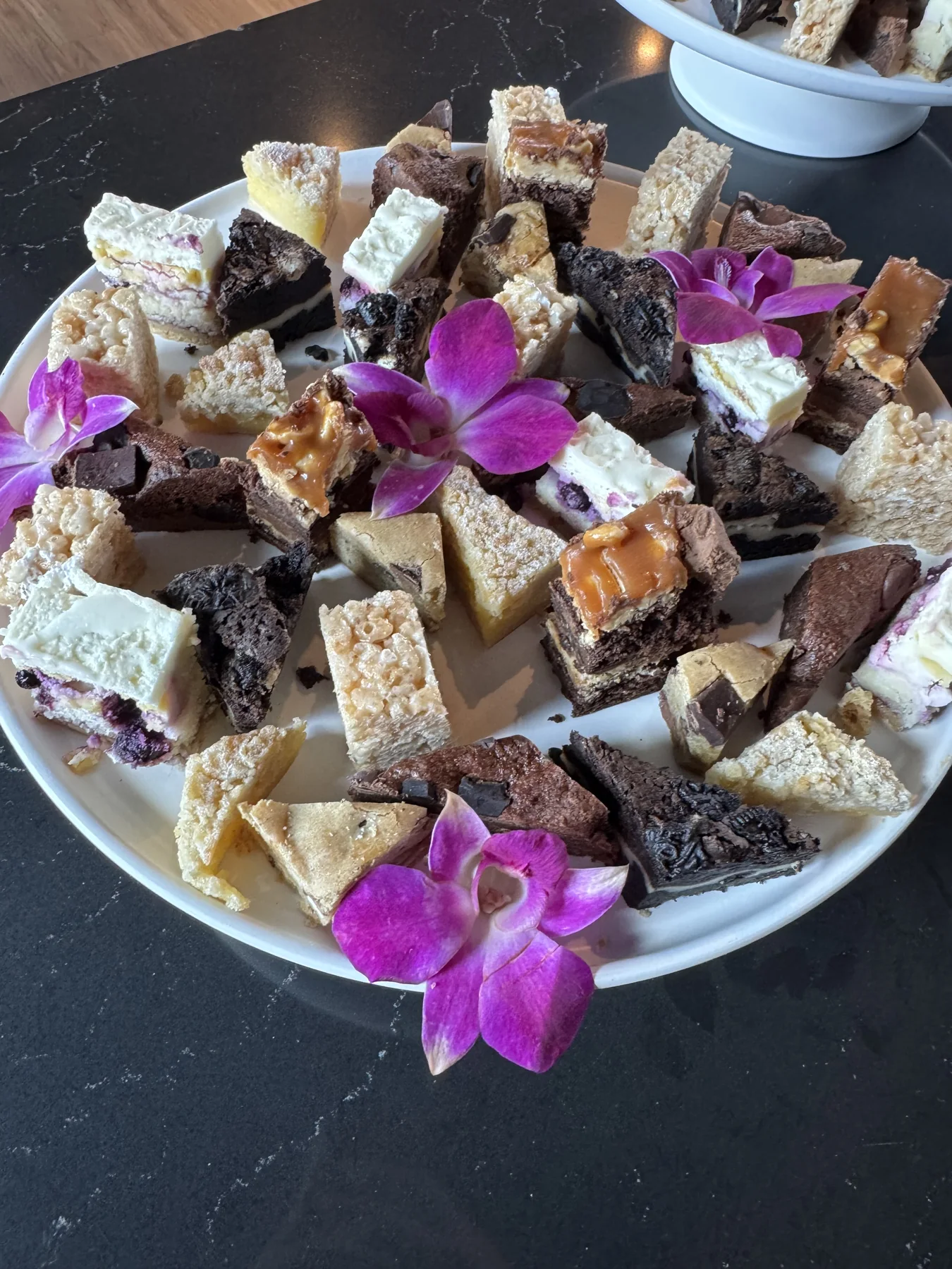 Platter of brownies, blondies and dessert bars with edible flowers