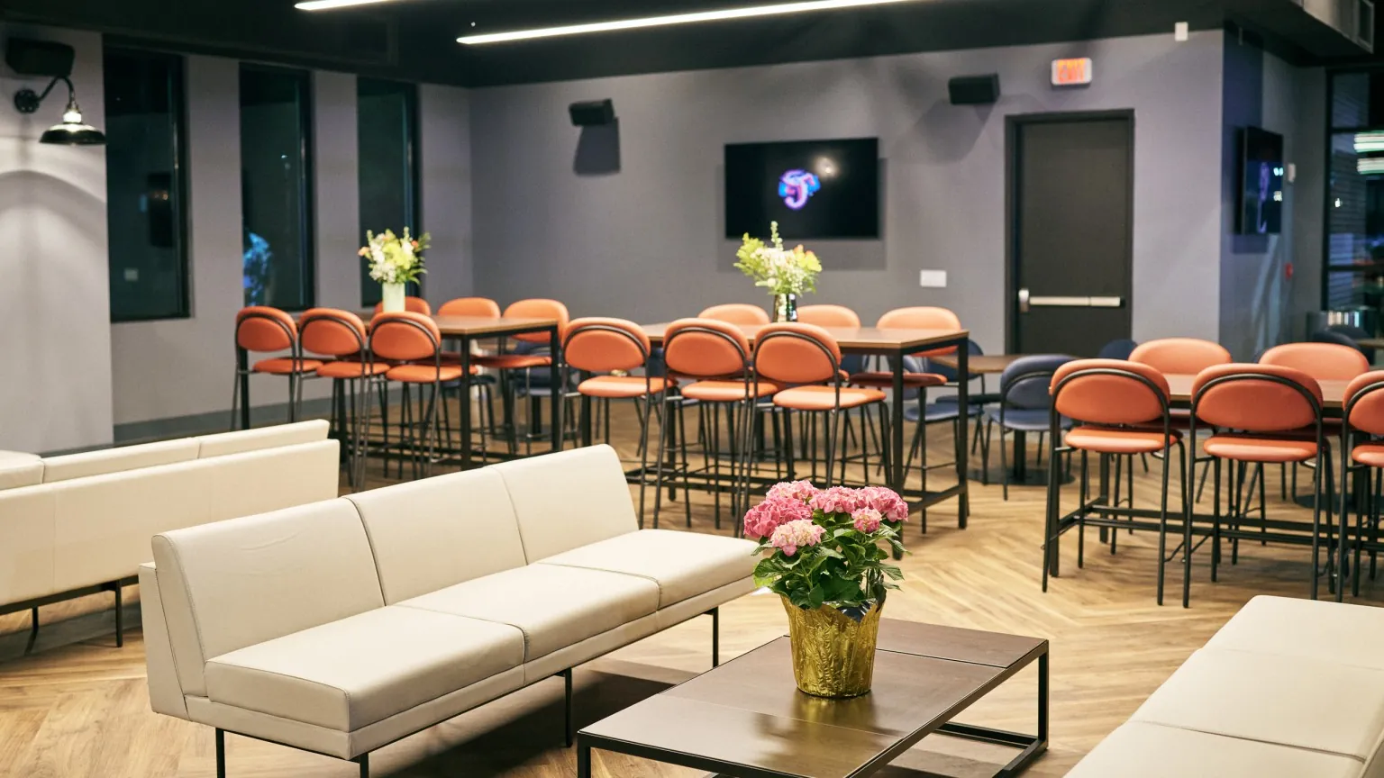 Soft lounge seating and cocktail tables overlooking the field